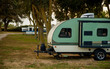 Small campers parked at campsite under trees 