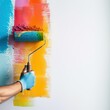 © STOCKYE STUDIO - hand holding a painter roller with paint, painting a white wall