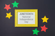 Juneteenth freedom day concept with colorful paper stars and frame on black background. Top view, flat lay