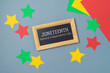 Juneteenth freedom day concept with colorful paper, blackboard and stars on gray background. Top view, flat lay