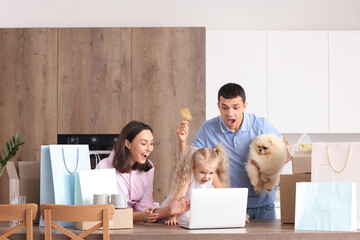 Wall Mural - Happy family with cute dog shopping online in kitchen