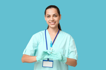 Sticker - Portrait of female doctor with syringe on blue background