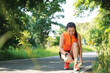 Running woman tying laces of running shoes before jogging through the road in the workout nature park.  Weight Loss and Healthy Concept, copy space