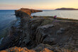 Cape Tobizin, Russky Island, Primorsky Krai, Russia. Sea of Japan. Evening seascape. View of the rocks on the seashore. Two girls are walking along the path. Travel and tourism in the Russian Far East
