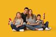 © Pixel-Shot - Beautiful family with flags of Canada sitting on yellow background