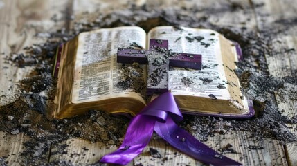 Cross and a purple ribbon on top of an open bible covered with ashes.