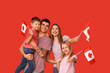 © Pixel-Shot - Beautiful family with flags of Canada on red background