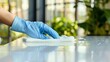 © KhaizanGraphic - Hand glove wiping a white table
