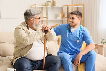 Sticker - Young caregiver taking care of senior man with stick at home