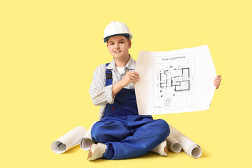 Canvas Print - Teenage architect with house plans sitting on yellow background