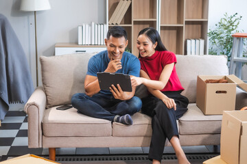 Young Asian couple relocating to a new house, joyfully packing and unpacking belongings. Expertise in moving, packing, togetherness, and creating a new home together.