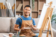 Middle-aged Asian man, skilled painting artist, donning an apron. Proficient in art, creativity, inspiration, and canvas work, utilizing various tools to express imagination.
