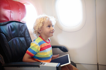 Child in airplane with tablet computer.