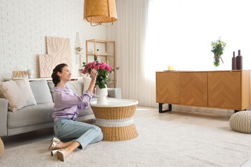 Wall Mural - Young woman with pink roses at home