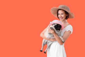 Poster - Young woman and cute pug dog in hats on orange background