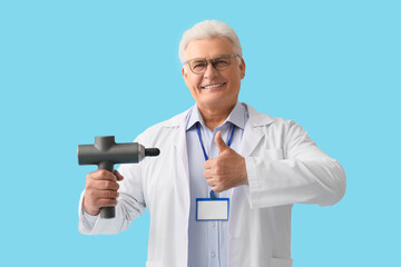 Sticker - Mature doctor with percussive massager showing thumb-up on blue background