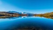 A tranquil lake reflecting the surrounding mountains and a clear blue sky, illustrating the importance of preserving freshwater ecosystems on Earth Day