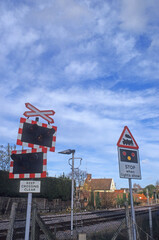 Railway warning and guidance furniture for train drivers. level crossing sign. train approaching lights. rail tracks Location Woodbridge Railway station Suffolk UK 2003