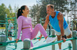 Athletic man and woman smiling and supporting each other during an outdoor workout session