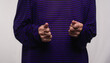 Close-up of an old woman's hands making a determined gesture while wearing a purple casual.
