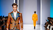 © fotogurme - Elegant Caucasian male model walking on fashion show catwalk, showcasing colorful designer jacket, with audience in background, related to Fashion Week events
