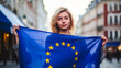 Young woman with the flag of the European Union against the background of city streets