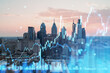 Double exposure of financial graphs superimposed on a cityscape, representing Philadelphia's skyline with a concept of business and technology. Double exposure