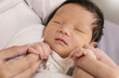 Portrait of asian parent hands holding newborn baby fingers, Closeup mother’s hand holding their new born baby. Love family healthcare and medical body part nursery together happy mother’s day concept