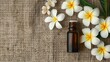 frangipani essential oil on burlap background