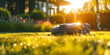 © MNStudio - Robot lawn mower on perfectly manicured lawn on sunny summer evening, on a backdrop of residential house backyard.