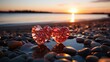 Two glass red hearts on a sandy beach against the backdrop of a sunset at sea. Romantic symbol of love.