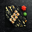 Classic sushi rolls with fish. Japanese food. On a black stone background. Top view.