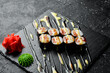 Classic maki rolls. On a black stone background. Top view.