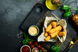Deep-fried cheese sticks with burger sauce. Close up. on a plate On a black stone background.
