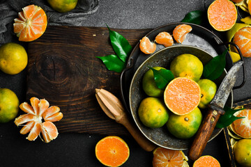 Wall Mural - Fresh ripe Tangerine orange. Top view, on a dark stone background. Autumn fruits.