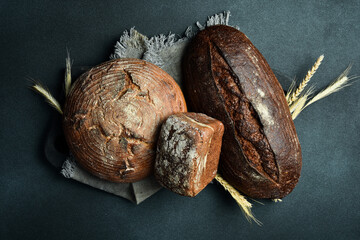 Wall Mural - Background of bread and pastries. Assortment of bread on a black stone table. Top view.