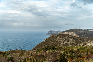 Wall Mural - Panoramic view, cliffs and Mediterranean sea on a cloudy morning day, in Jávea, Alicante (Spain).