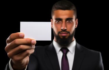 A man is holding a white card in his hand