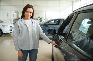 Happy friendly woman customer female buyer client chooses auto wants to buy new automobile