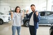 © Serhii - The successful visit to the dealership. Happy young couple chooses and buying a new car for the family