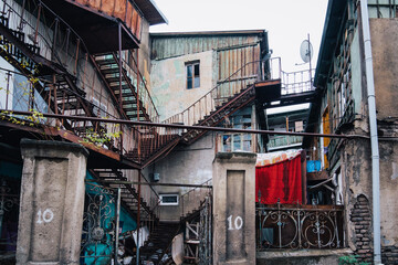 Wall Mural - View on dilapidated houses in Tbilisi Old town (Georgia) with iron rusty staircases, balconies and clothesline