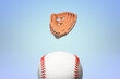 Floating baseball glove above ball on blue