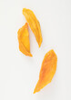 Macro slices of dried mango slice on white.