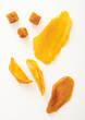 Various dried sweet mango slices and balls on white background.