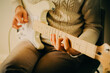 A man wearing a white sweater is playing music on a white electric guitar during a music lesson.