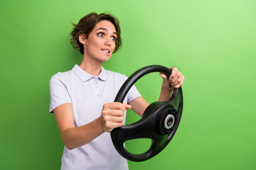 Poster - Photo of young lady hold steering wheel automobile bite lips scared passing examination drivers license isolated on green color background