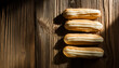 Freshly baked eclairs with white glazing on wooden table. Delicious and sweet food. Tasty dessert.