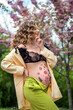 pregnancy, a young mother in a stylish bright outfit, a happy girl has the secret of a new life
