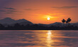 Beautiful orange sunset over lake with mountains and tropical forest