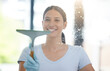 Window, woman and cleaning with detergent or spray, hygiene and product for hospitality, maintenance and service. Cleaner, glass door and chemical for housekeeping with gloves and wipe liquid away